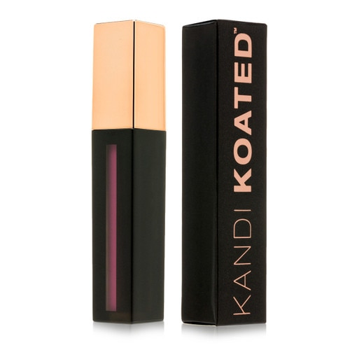 A closed black rectangular tube of liquid suede matte lip color in “Arm Candy” with a rose gold cap. Beside it stands its black and rose gold box.